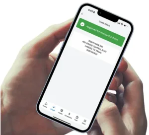 A person holding a mobile phone in their hands. The mobile phone shows an approved credit check within the Porter Freight app.